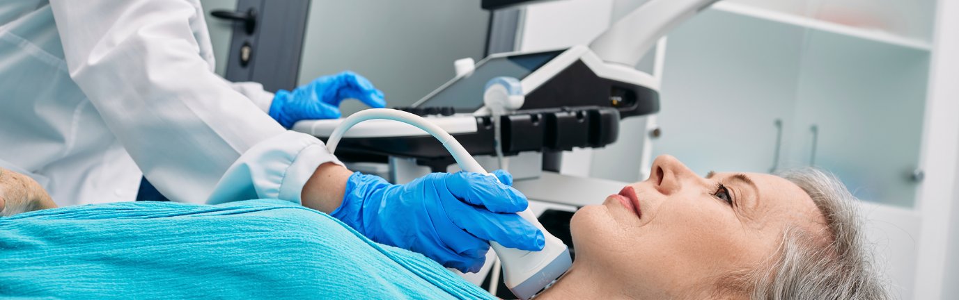 Ecografia alla tiroide di una paziente anziana effettuata da un medico dotato di sonda ecografica