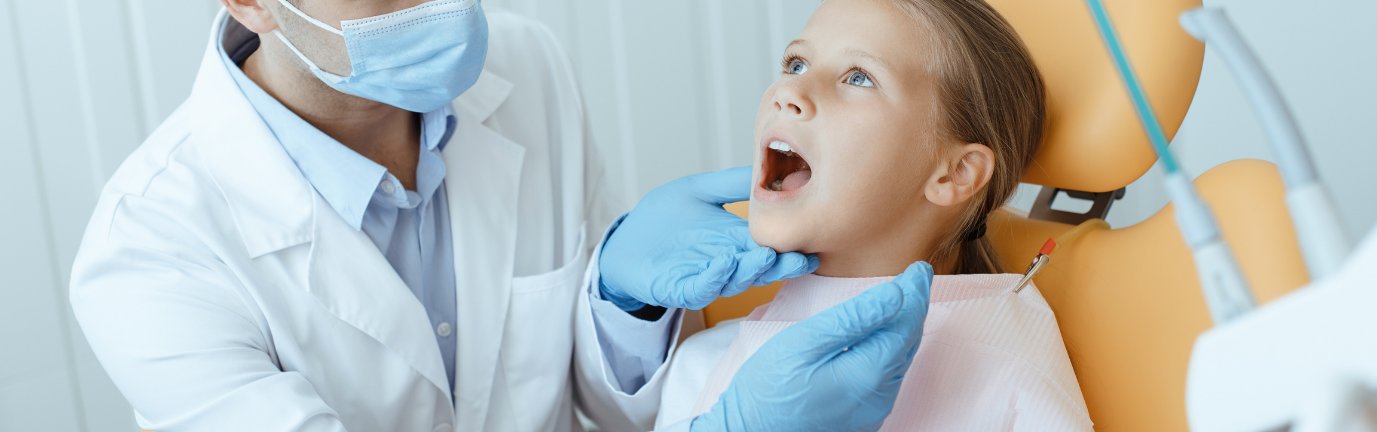 Pedodonzista che controlla i denti ad una bambina